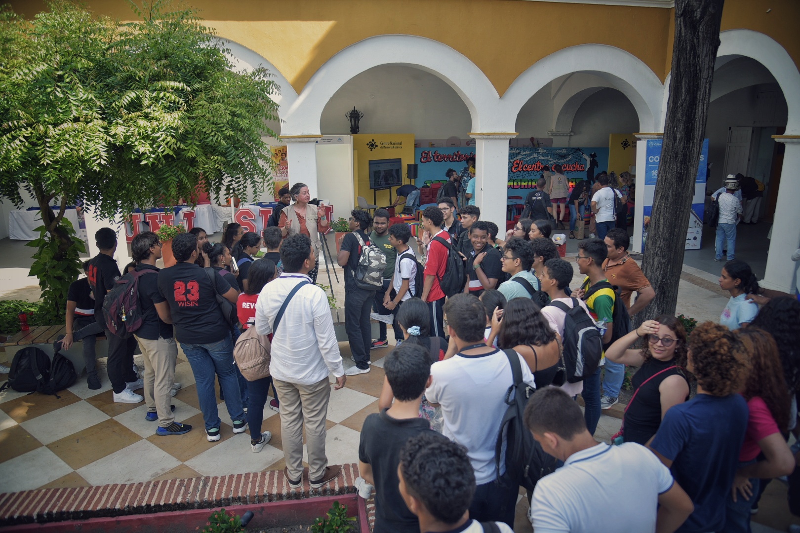 Un grupo de estudiantes se acerca para escuchar la visita por el Archivo de los Derechos Humanos del CNMH liderada por Nartyjulieth Vásquez.