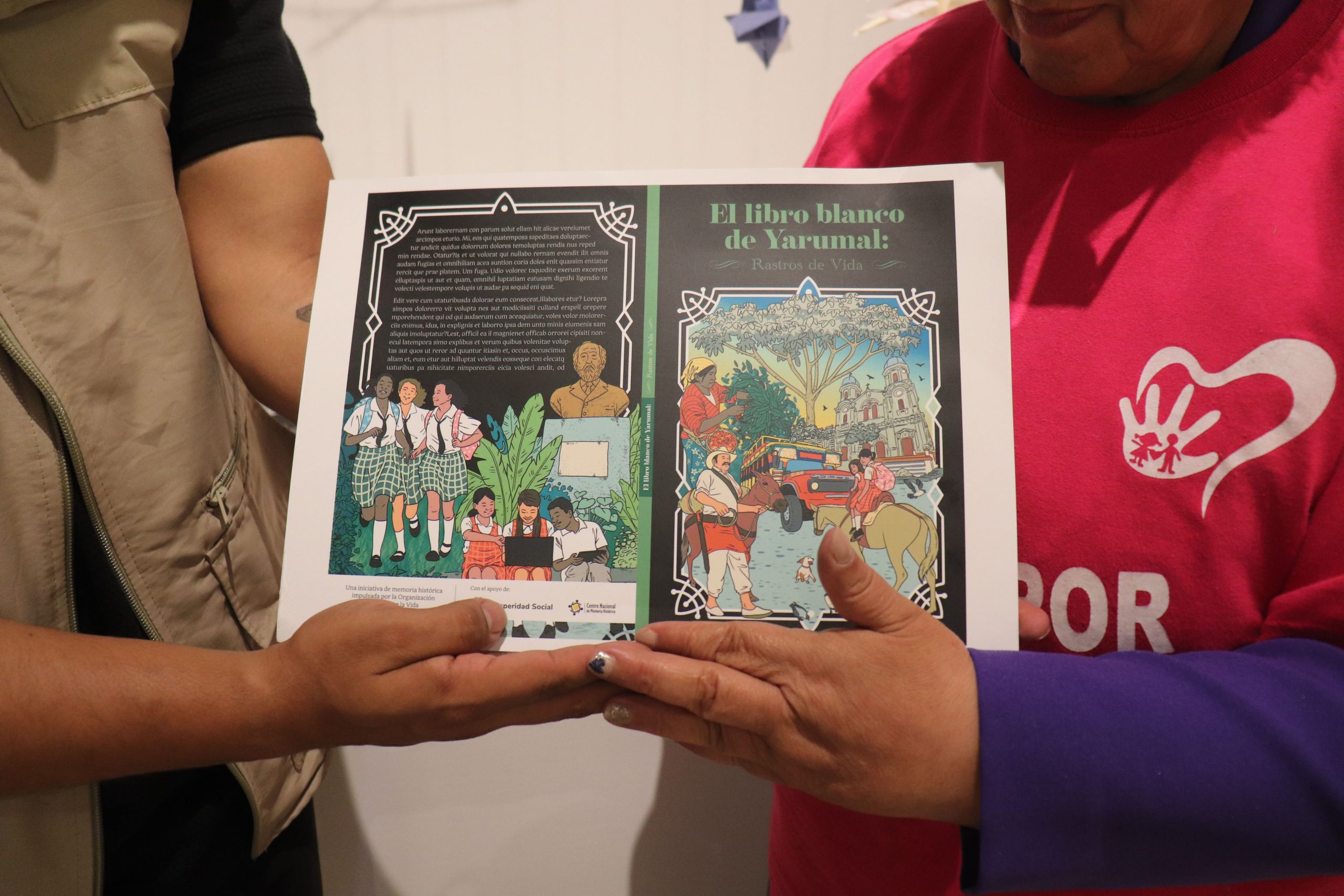Magdalena Calle, coordinadora de Madres por la Vida de Yarumal, recibe la propuesta gráfica del Libro Blanco de Yarumal.