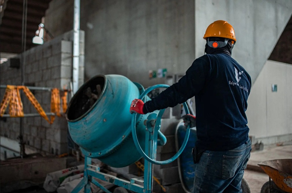 Trabajador mezclando concreto en la obra del Museo